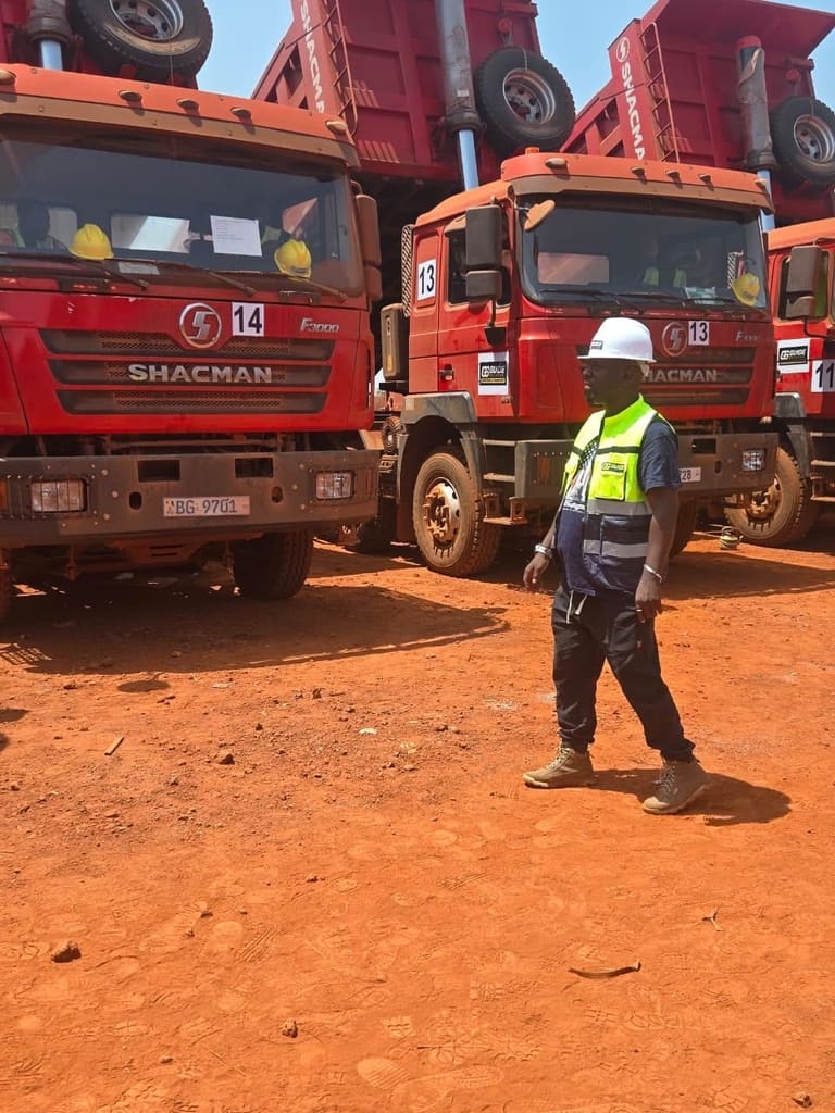 Agent en gilet haute visibilité et casque blanc devant le camion-benne rouge numéro 14